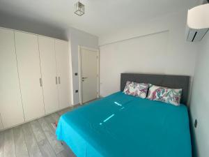 a bedroom with a blue bed and white cabinets at Marina Guest House in Çeşme