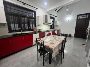 a kitchen with a table with chairs and red cabinets at Villa J&T in Katunayake