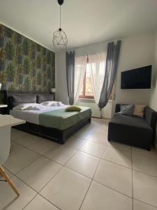 a bedroom with a bed and a couch at B&B 30 mt dal Duomo in Benevento