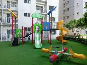 a playground with different types of play equipment in front of a building at AA's Property in Sampong