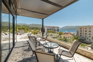 梅尔吉恩Apartmani Jakšić的阳台配有桌椅,享有海景。