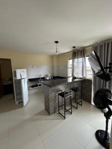 a kitchen with a counter and a refrigerator at Liszen flats in Porto De Galinhas