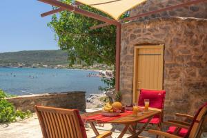 a table with a bowl of fruit sitting on top of a patio at Το Καμίνι, πέτρινη κατοικία πάνω στη θάλασσα The Kiln House Kamini, Retreat on the beach in Aspropótamos