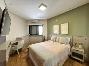 圣若泽杜斯坎普斯Summit Flat, ótima localização, limpeza diária, academia e piscina的一间卧室，配有一张床、一张书桌和一扇窗户