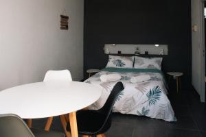 a bedroom with a bed and a table and chairs at OCEAN 53 cottage avec piscine privée in Lesperon