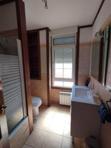 a bathroom with a sink and a toilet and a window at hotel el candano in Pravia