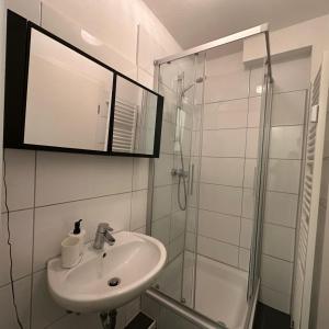 a white bathroom with a sink and a shower at WDI - WorkersSpace in Bochum