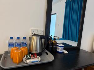 un vassoio con macchinetta del caffè e bottiglie d'acqua su un bancone di Hotel Coral Bay a Trincomalee
