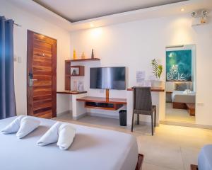a bedroom with a bed and a desk with a television at Yellow Mango Resort Bohol in Panglao Island