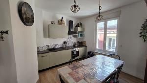 a kitchen with a dining room table and a table and chairs at Appartement plage & port in Le Tréport
