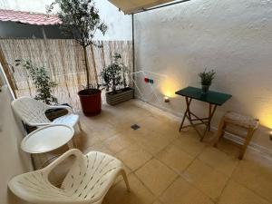 a room with white chairs and a table and plants at Bari in Acropolis in Athens +17 photos
