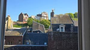 a view from a window of roofs of buildings at Appartement plage & port in Le Tréport