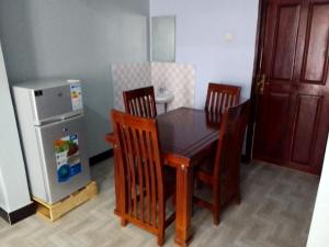 a kitchen with a table and chairs and a refrigerator at CTS Suites in Kampala