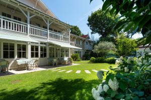 a large white house with a yard with a patio at La Villa du Moulleau in Arcachon