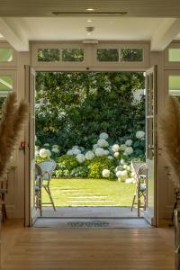 an open door to a garden with chairs outside at La Villa du Moulleau in Arcachon