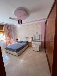 Un dormitorio con una cama y un televisor. en panoramic house, en Chefchaouen
