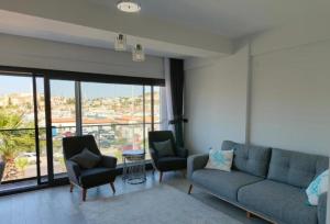 a living room with a couch and two chairs at Marina Guest House in Çeşme