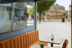 a table and chairs in a restaurant with a view of a street at Station Suites Aparthotel in Middlesbrough
