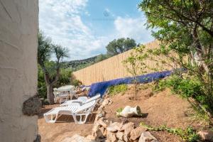 un grupo de sillas blancas sentadas en la cima de una colina en Bellavista, en Capitana