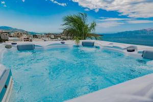 a large swimming pool with a palm tree in it at Skyline penthouse Sarande in Sarandë