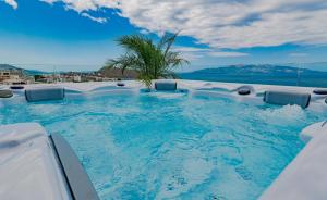 a hot tub with a palm tree in the middle at Skyline penthouse Sarande in Sarandë