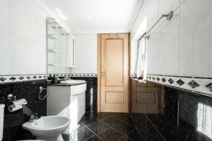 a black and white bathroom with a toilet and a sink at Casa do Meia Noite in Gralhas