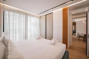 a bedroom with a white bed and a large window at Skyline penthouse Sarande in Sarandë +45 photos