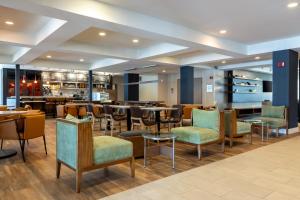 a restaurant with chairs and tables and a bar at Courtyard by Marriott North Charleston Airport Coliseum in Charleston