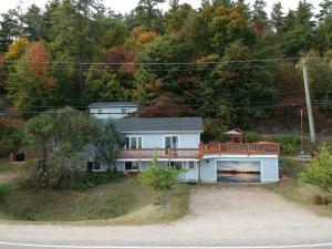 una casa bianca con un ponte su una collina di Chalet Bleu a Lac Sainte-Marie
