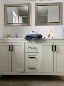 bagno con lavandino e 2 specchi di Chalet Bleu a Lac Sainte-Marie