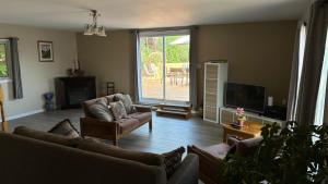 un soggiorno con due divani e una TV di Chalet Bleu a Lac Sainte-Marie