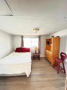 una camera da letto con un letto, una sedia e una finestra di Chalet Bleu a Lac Sainte-Marie