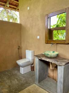 a bathroom with a toilet and a sink and a mirror at Hello Homestay in Galle