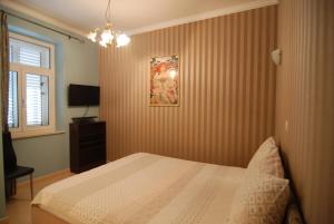 a bedroom with a bed and a picture on the wall at Villa Artpalathos in Kaštela