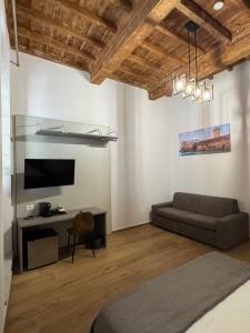 a living room with a couch and a tv at San Giovanni Rooms Livorno in Livorno