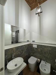 a bathroom with a sink and a toilet and a mirror at San Giovanni Rooms Livorno in Livorno +64 photos