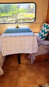 a bed in a room with a table in a room at Caravane Zen & Jacuzzi proche des grottes de Bèze in Bèze +9 photos