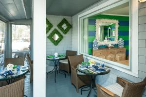 a porch with two tables and a mirror at The Trellis House in Ogunquit