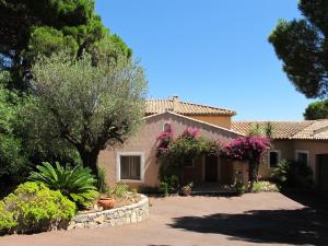 une maison avec des fleurs et des plantes devant dans l'établissement Villa La Pinède Les Issambres Golf de Saint Tropez - Vue mer panoramique de la piscine, à Roquebrune-sur Argens