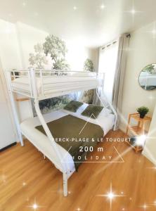 ベルク・シュル・メールにあるBerck-Place & Le Touquet - Studio sur la Côte d'Opaleのウッドフロアの客室で、白い二段ベッド1台が備わります。