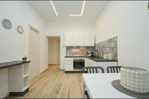 a kitchen with white cabinets and a table and chairs at Residenza il Bruco N 3, 300 meters from the subway in Cernusco sul Naviglio