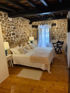 a bedroom with a large bed and a stone wall at La Quintana de Los Valles in Benia