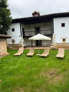 a group of chairs and an umbrella in a yard at La Quintana de Los Valles in Benia