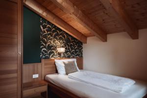 Cama en habitación con pared verde en Der Mittermoar, en Bresanona 82 fotos más