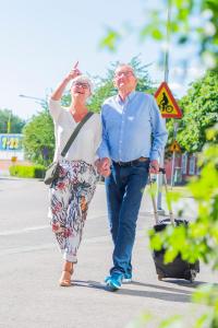 un uomo e una donna anziani che camminano per strada di Port Hotel a Karlshamn