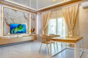 a living room with a table and a large aquarium at Тематични апартаменти Дубай и Малдиви in Néa Péramos