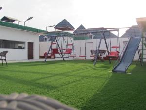 une aire de jeux avec des chaises et un toboggan sur une pelouse dans l'établissement أكواخ الدغاس غرفة بجلسه خارجيه, à Taif