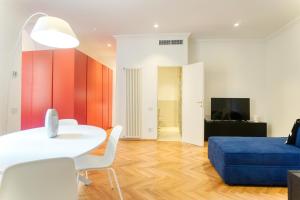 un soggiorno con tavolo bianco e divano blu di Cadorna Prestigious Apartment - Modern Architecture in front of the Station a Milano