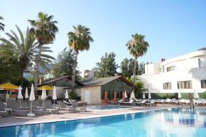 une piscine dans un hôtel avec des chaises et des parasols dans l'établissement Ada Newday Resort Hotel, à Kusadası 122 autres photos