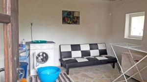 ein Wohnzimmer mit einer schwarz-weißen Couch und einer Waschmaschine in der Unterkunft Bulgarian country house near the sea in Banya